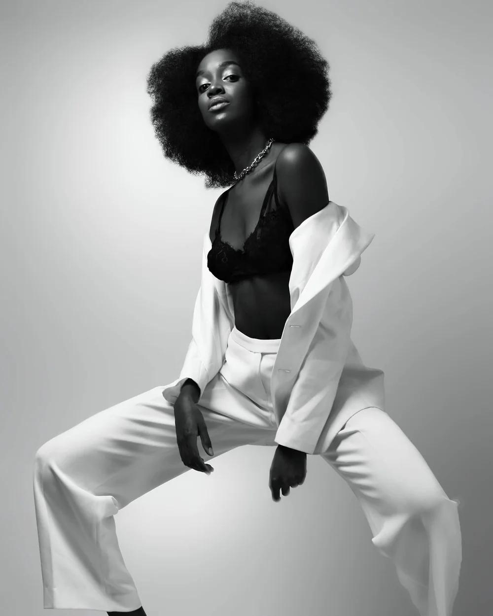 Daha Garcés en blanco y negro, con traje blanco, en pose de estudio